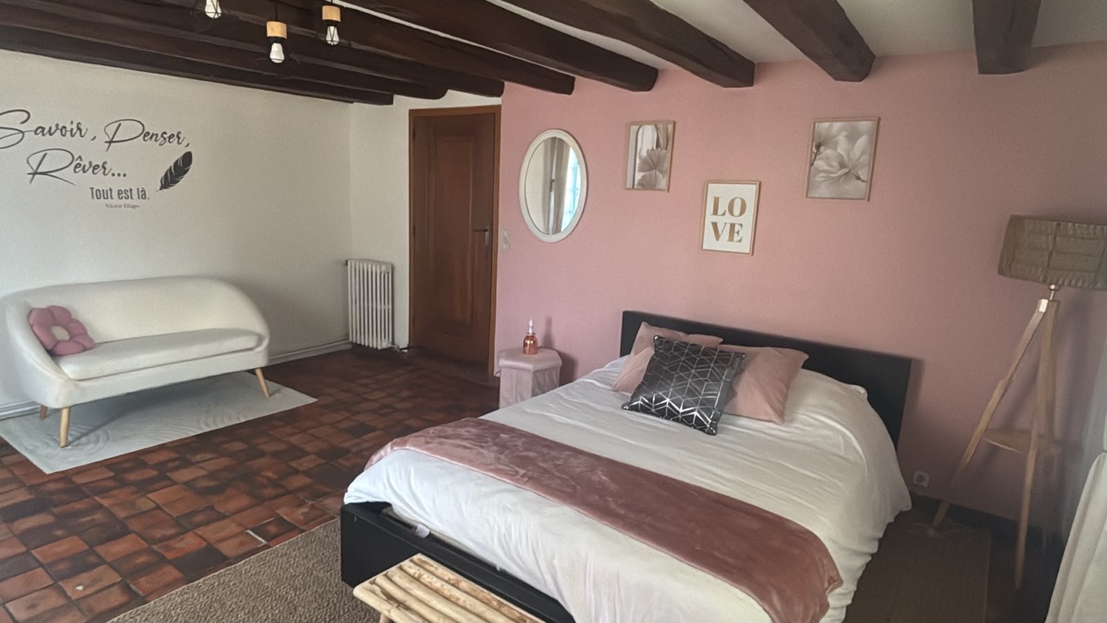 Chambre d'hôte spacieuse avec lit double, poutres apparentes et coin salon