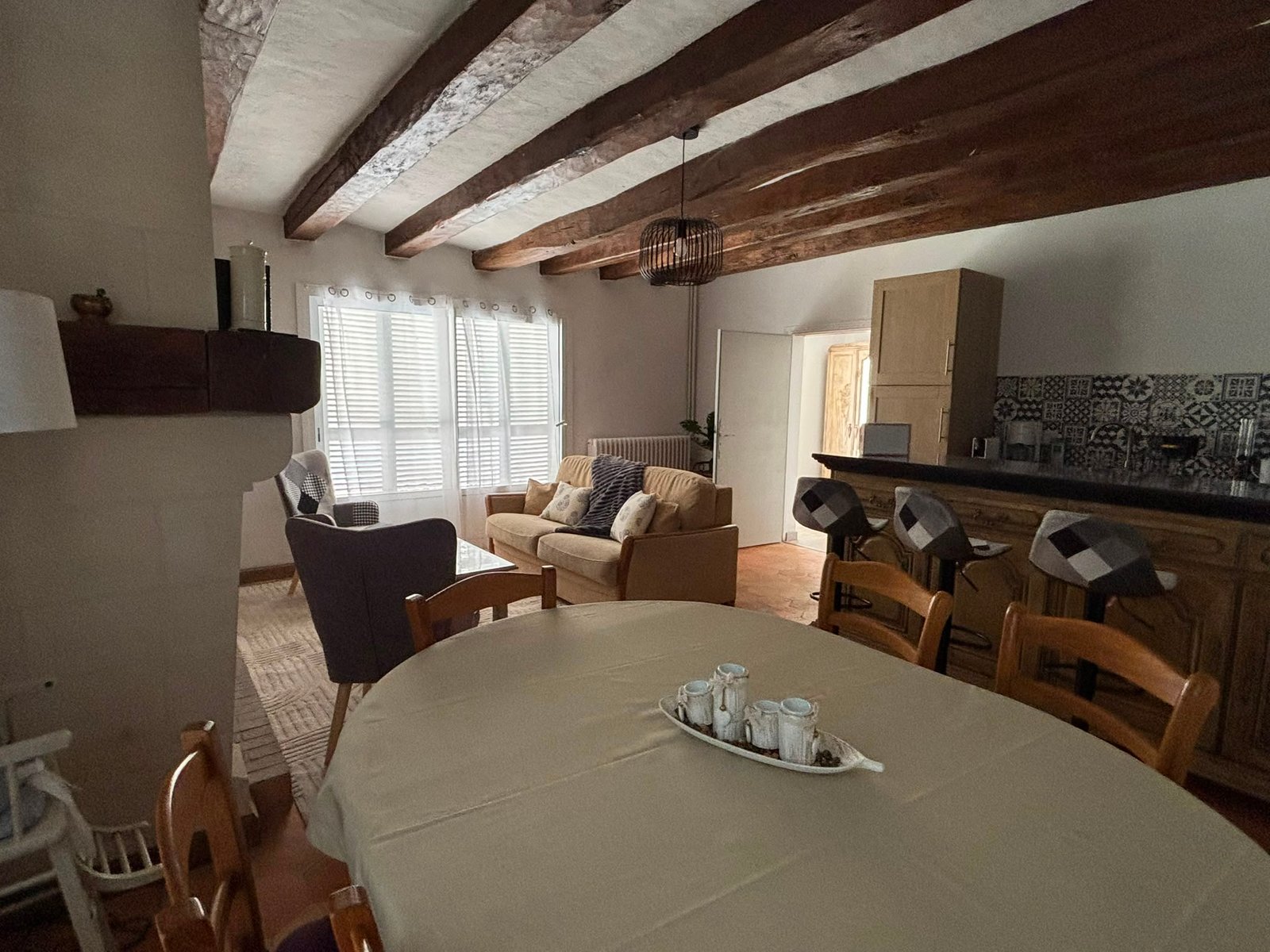 Pièce de vie du gîte Marie-France avec poutres apparentes et espace repas